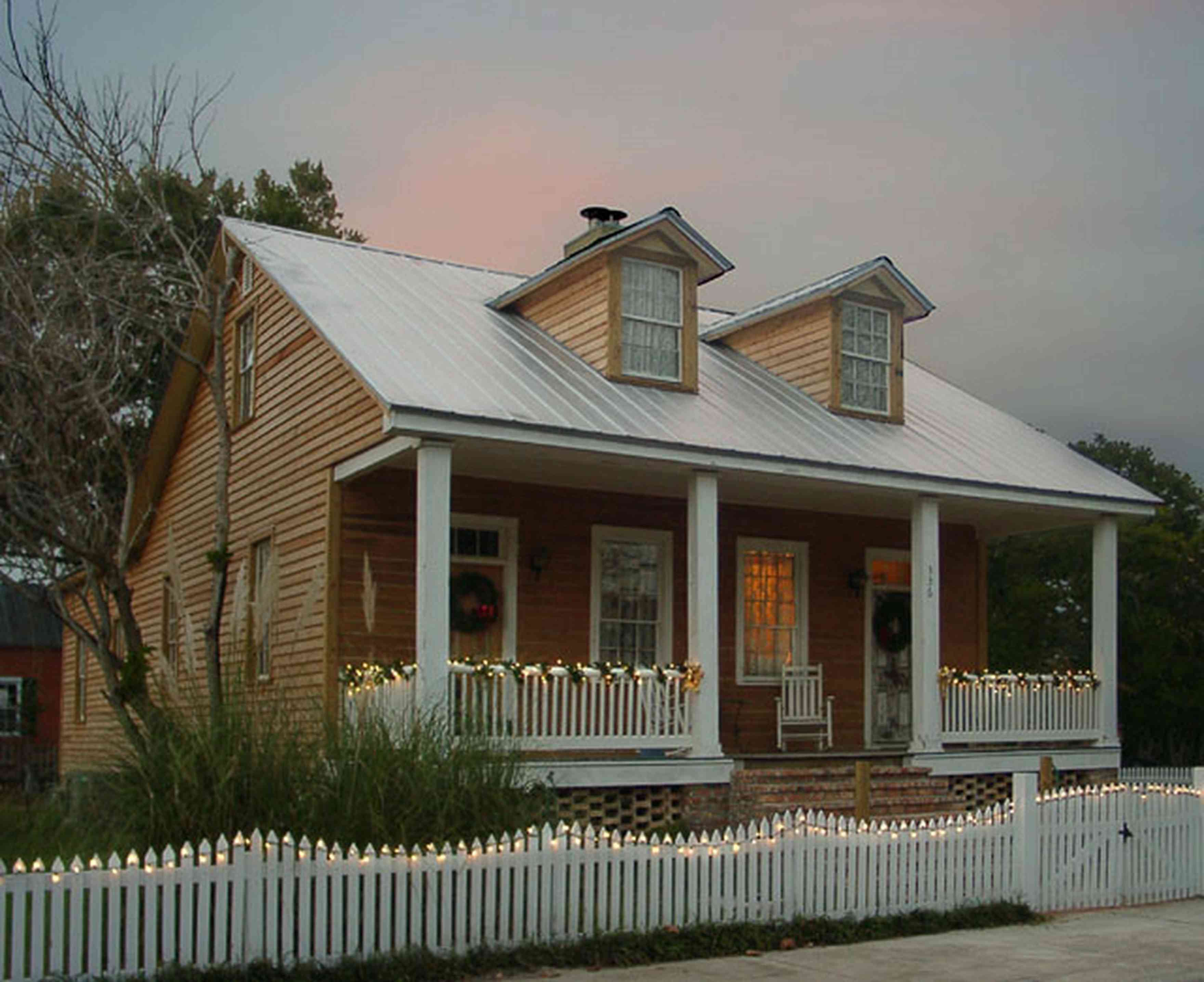 Pensacola:-Seville-Historic-District:-336-East-Intendencia-Street_02.jpg:  christmas decorations, picket fence, garland, wreath, porch, rocking chair, lace curtains