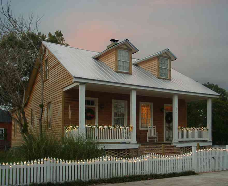 Pensacola:-Seville-Historic-District:-336-East-Intendencia-Street_02.jpg:  christmas decorations, picket fence, garland, wreath, porch, rocking chair, lace curtains