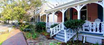 Pensacola:-Seville-Historic-District:-433-East-Zaragoza-Street_03.jpg:  victorian house, victorian front porch, gingerbread, brick sidewalk, wicker furniture, brick sidewalk, historic village