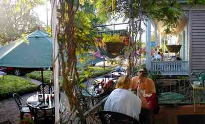Pensacola:-Seville-Historic-District:-Tre-Fratelli-Italian-Restaurant_Tres_10.jpg:  dining, restaurant, umbrella table, wisteria vine, hanging basket, sidewalk cafe, oak trees