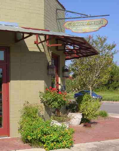 Pensacola:-Seville-Historic-District:-Woodcock-Galleries_02.jpg Pensacola:-Seville-Historic-District:-Woodcock-Galleries_02.jpg: rose bushes, brick sidewalk, historic district, antique shop