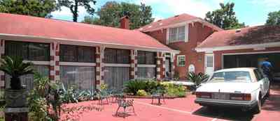 Scenic-Highway:-3780-Scenic-Ridge-Drive_02a.jpg:  red brick house, colonial style architecture, rolls royce, patio furniture, sego palm tree, red concrete