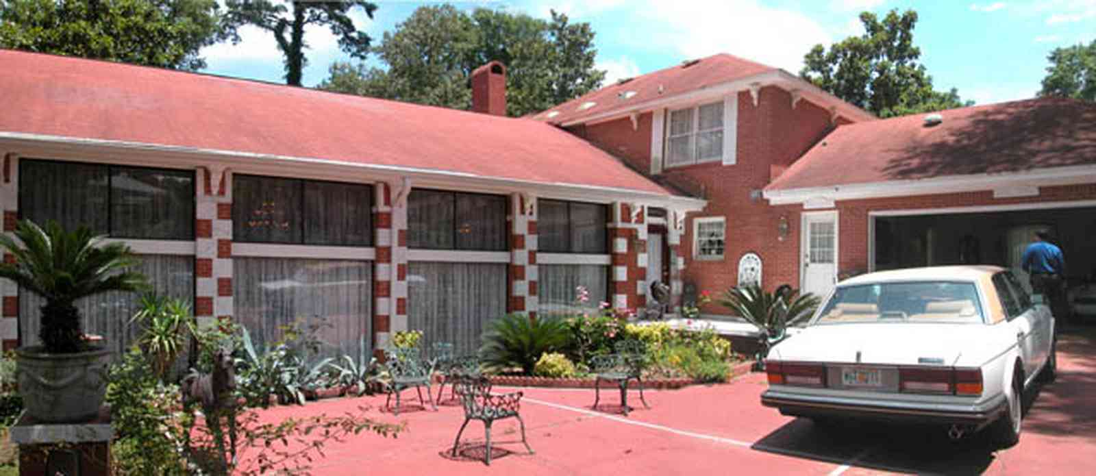 Scenic-Highway:-3780-Scenic-Ridge-Drive_02a.jpg:  red brick house, colonial style architecture, rolls royce, patio furniture, sego palm tree, red concrete