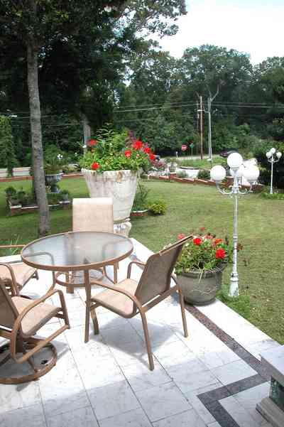 Scenic-Highway:-3780-Scenic-Ridge-Drive_31.jpg:  veranda, front porch, pot of geraniums, glass top table, lawn furniture, 