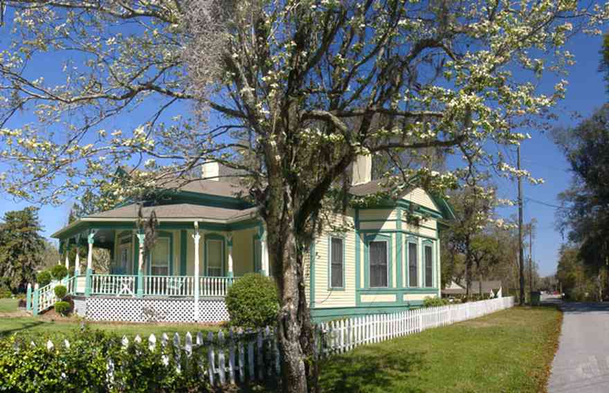 Milton:-Historic-District:-202-Berryhill-Street:-Chadwick-Hartsell-House_03.jpg:  dogwood tree, picket fence, steamboat house, porch, shutters, wooden