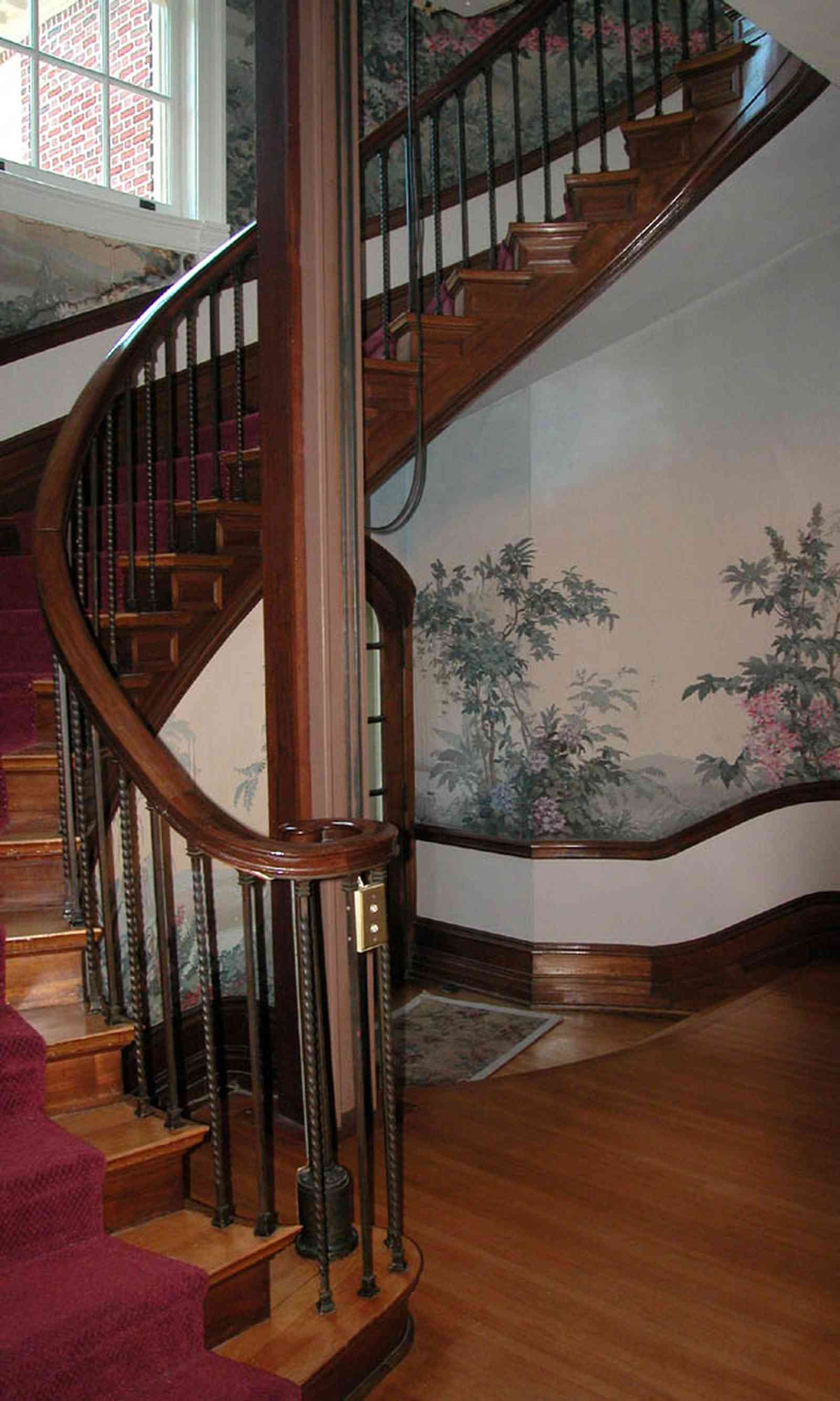 North-Hill:-105-West-Gonzales-Street_29.jpg:  grand foyer, oriental rug, spiral staircase, chandelier, hardwood floors, french colonial architecture, handpainted wallpaper